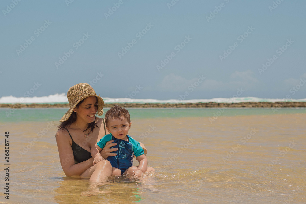 mom and son playing on the shallow golden beach Playa La Posita in Piñone It's right on PR-187, and one of its distinctive . mom and son playing on the shallow golden beach Playa La Posita in Piñone It's right on PR-187, and one of its distinctive .