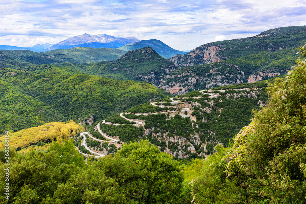 A winding mountain road in the Vikos gorge overlooking the hills and mountains of Zogori.