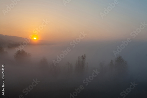 Beautiful foggy autumn sunrise landscape.