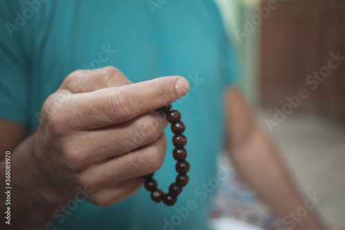 Selective focus on the hand of a man with a chakra wooden ball bracelet