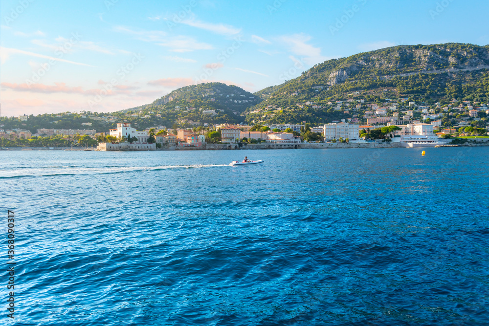 Fototapeta premium A man fishes in a small boat off the shores of the Saint-Jean-Cap-Ferrat on the French Riviera Cote d'Azur