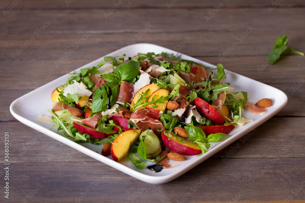 Peach and cured ham salad with cheese, basil, arugula and cucumbers