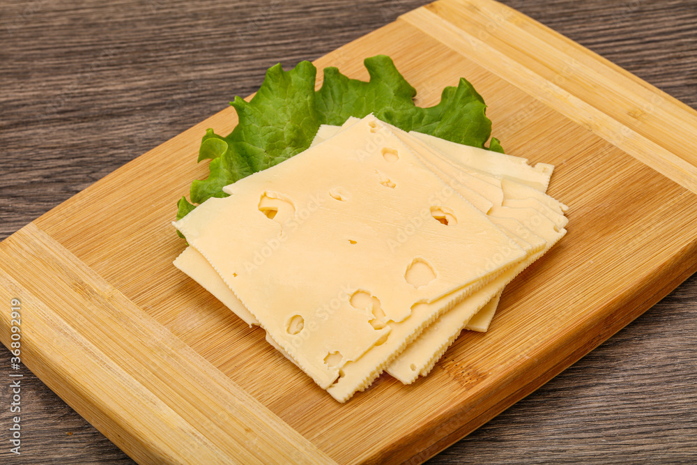 Sliced yellow cheese over board