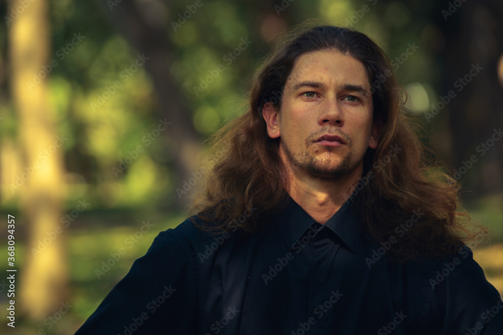 Handsome bearded businessman with long hair at the park Handsome bearded businessman with long hair at the park