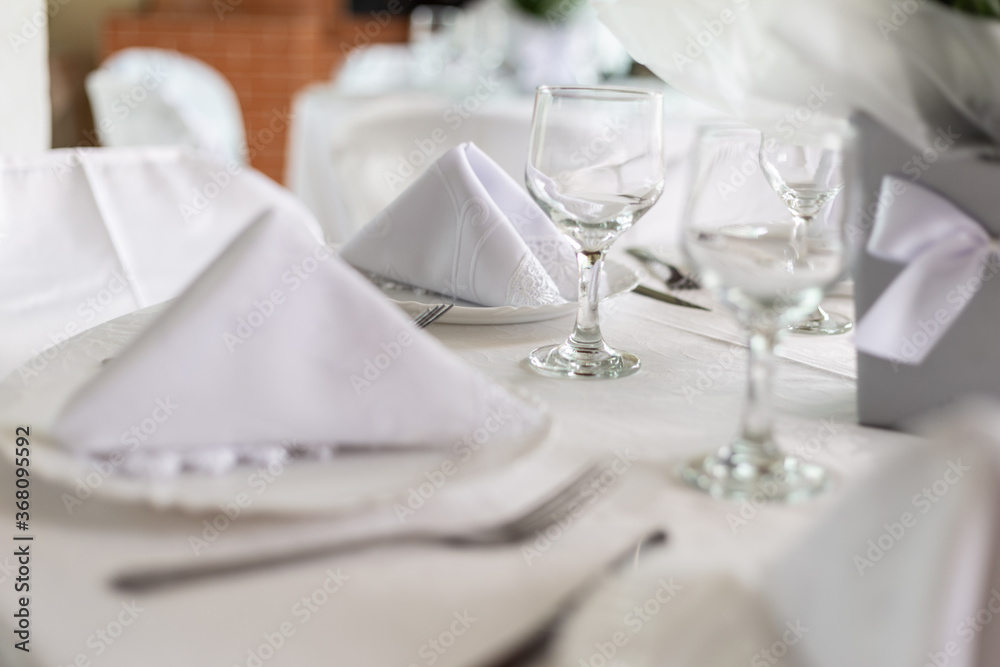 Mesa de convidados com forro branco, pratos, copos e guardanapos. Mesa de convidados com forro branco, pratos, copos e guardanapos.