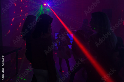 Ambiente de boate, com luzes coloridas e várias pessoas dançando.