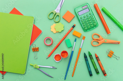 School supplies on green color background, top view