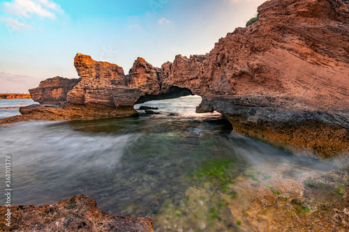 Stone arch in the stunning lagoon of Nahsholim Beach, Haifa area of Northern Israel.