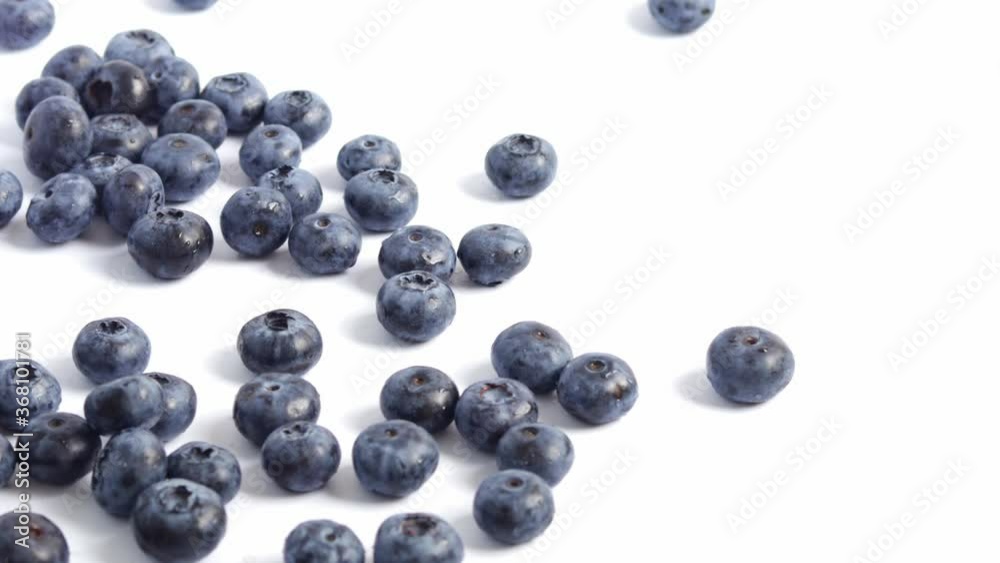 A handful of blueberries are added to the pile, white background.