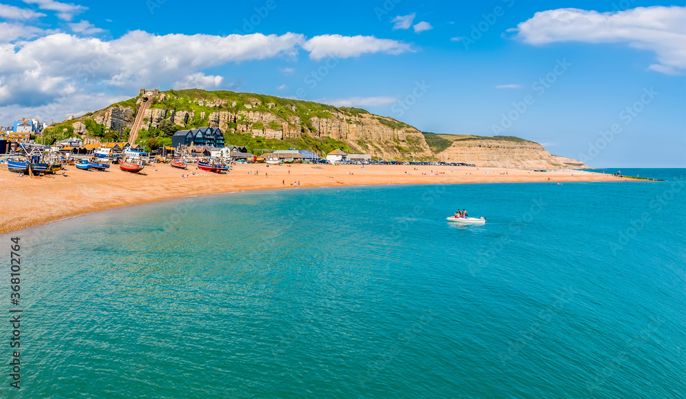 A view from the sea towards the beach and east cliffs in Hastings, Sussex in summer