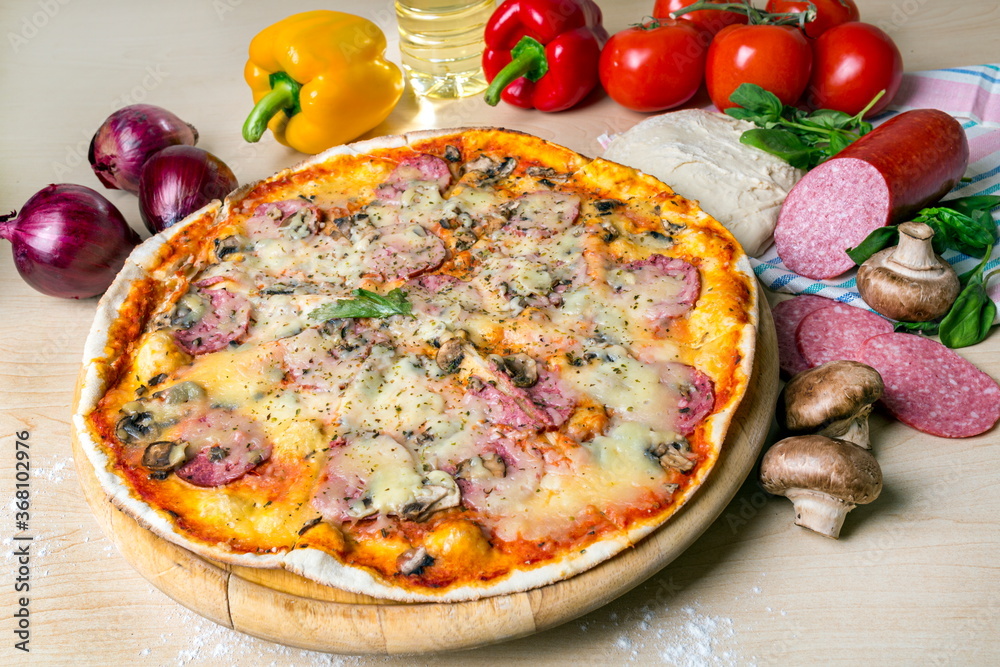Pizza with salami sausage mushrooms tomatoes sweet pepper and cheese