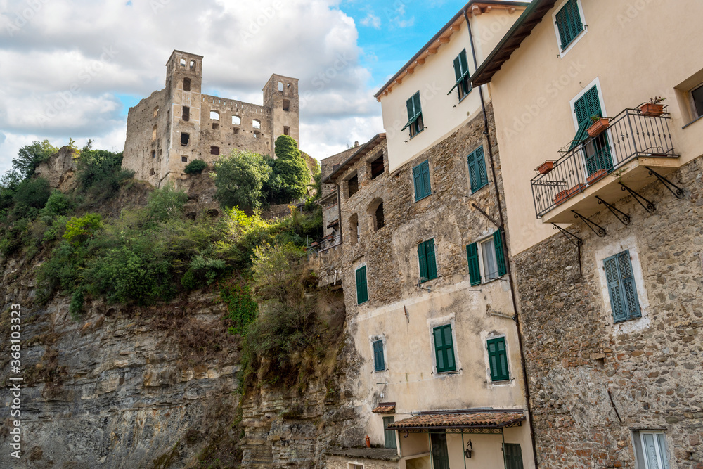 The ancient hilltop castle of Dolceacqua, Italy, and walled apartment houses in the Imperia Ligurian region, on a partly cloudy day