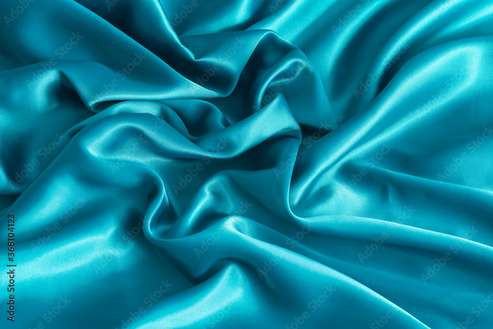 Folded aqua blue satin texture. Light blue satin fabric close up. Abstract background of luxury satin textile Folded aqua blue satin texture. Light blue satin fabric close up. Abstract background of luxury satin textile