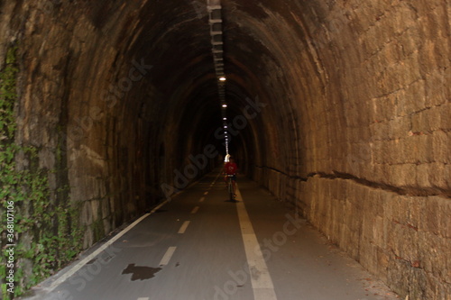 a caucasic child ride along a train tunnel in five land national park