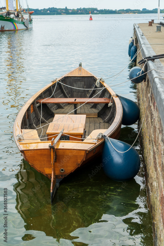old wooden rowing boat on the quay wall