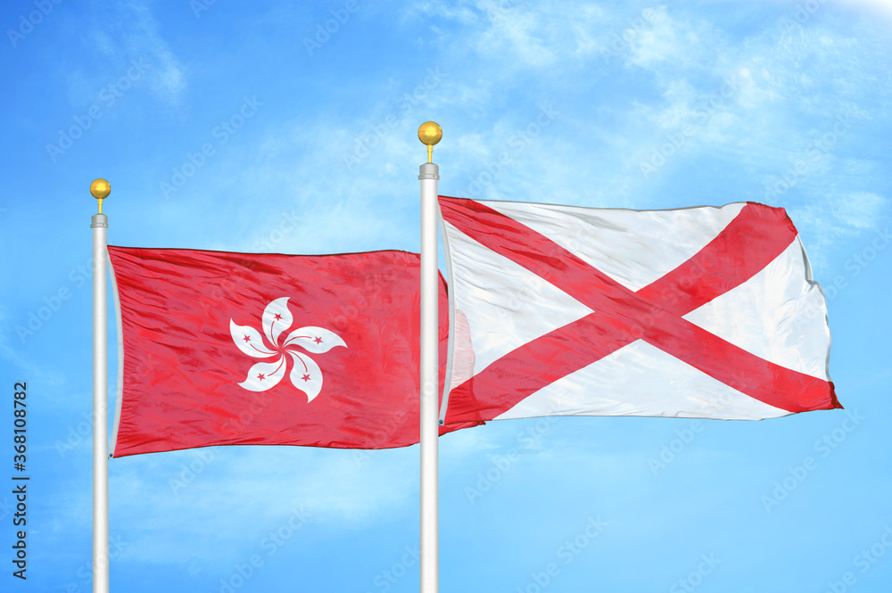 Hong Kong and Northern Ireland two flags on flagpoles and blue cloudy sky Hong Kong and Northern Ireland two flags on flagpoles and blue cloudy sky