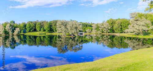 Panorama of summer Park . Park Russia . Public park. Mirror image in the Park by the water with the bridge . Summer Park. The lake in the Park. City park. Beautiful summer landscape.