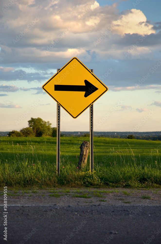 Yellow Sharp Curve Road Sign with Beautiful Clouds in the Background Yellow Sharp Curve Road Sign with Beautiful Clouds in the Background