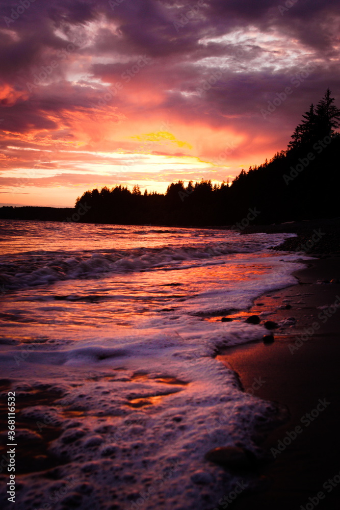 beautiful red and pink sunset reflecting of foamy sea