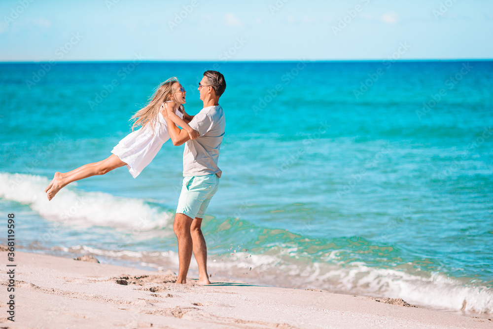 Little girl and happy dad having fun during beach vacation