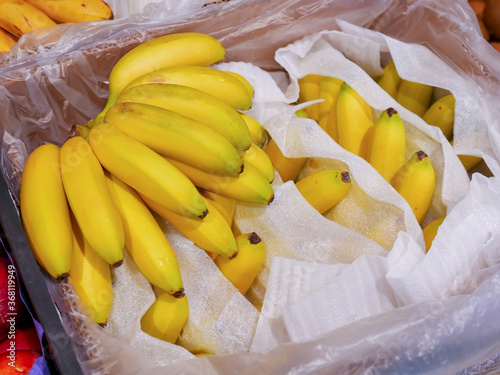 Ripe yellow bananas in box in supermarket. Close-up