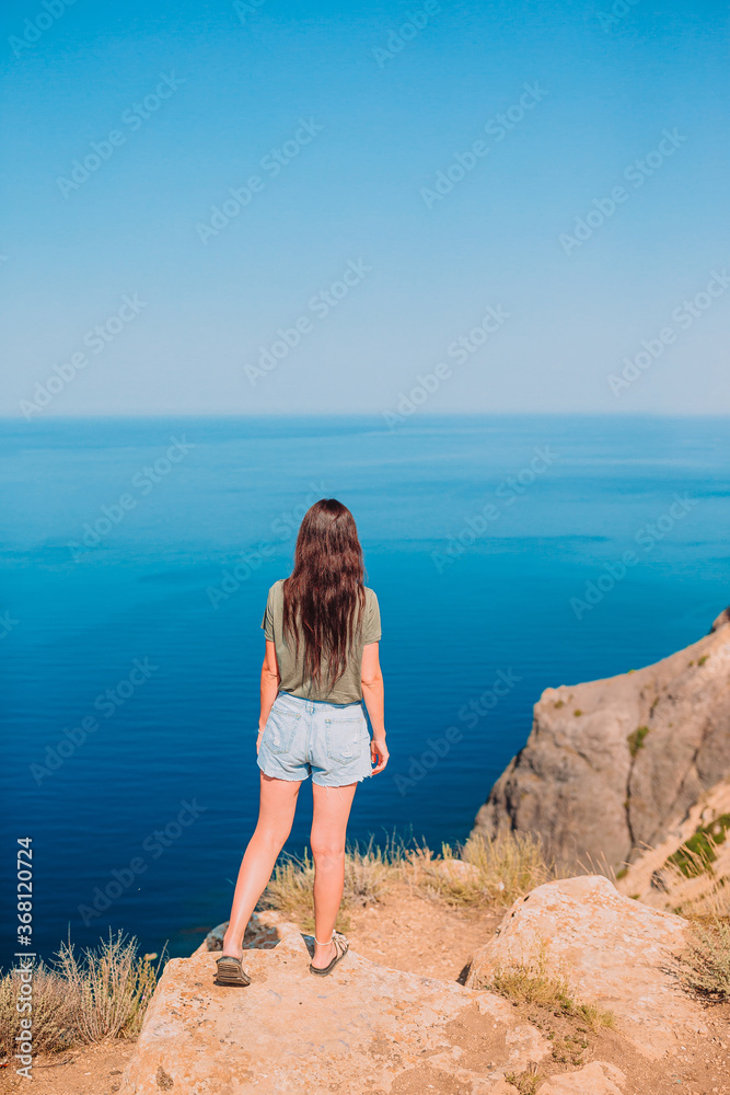 Tourist woman outdoor on edge of cliff seashore Tourist woman outdoor on edge of cliff seashore