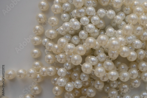 long pearl beads lie on a white table