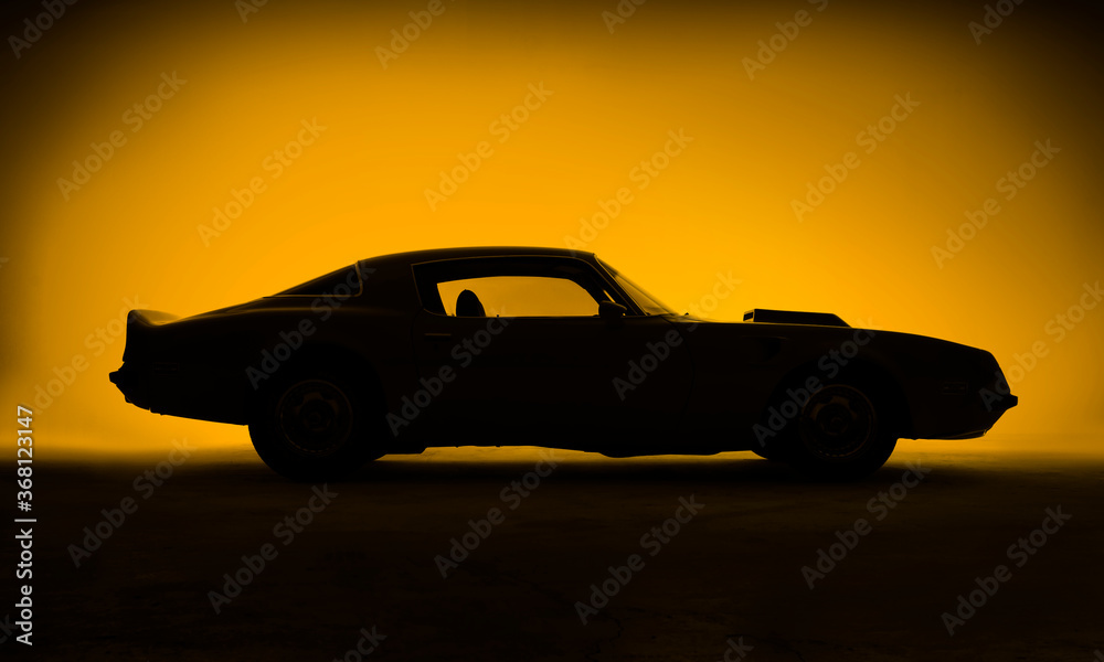 Silhouette of an old fashion muscle car on a yellow background.