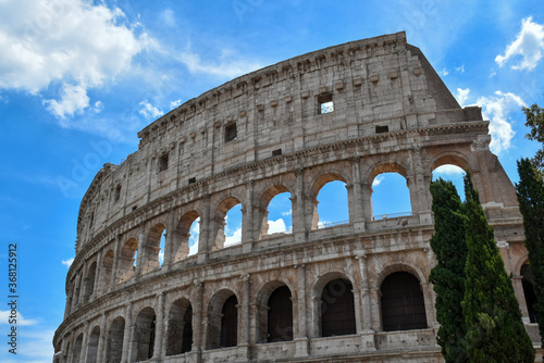 Detail of the famous Italian Colosseum monument in Rome, built in marble, with a blue sky background