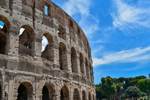 Detail of the famous Italian Colosseum monument in Rome, built in marble, with a blue sky background