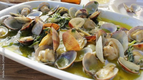 Eating portuguese steamed Clams with delicious sauce. Close-up view