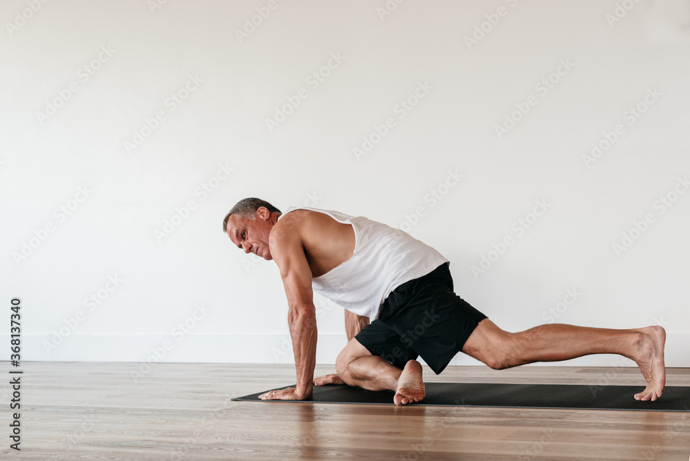 Senior man doing yoga stretching Senior man doing yoga stretching