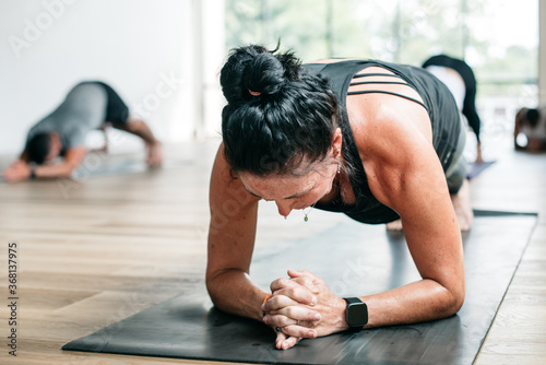 Woman practicing hot yoga holding plank pose  photo