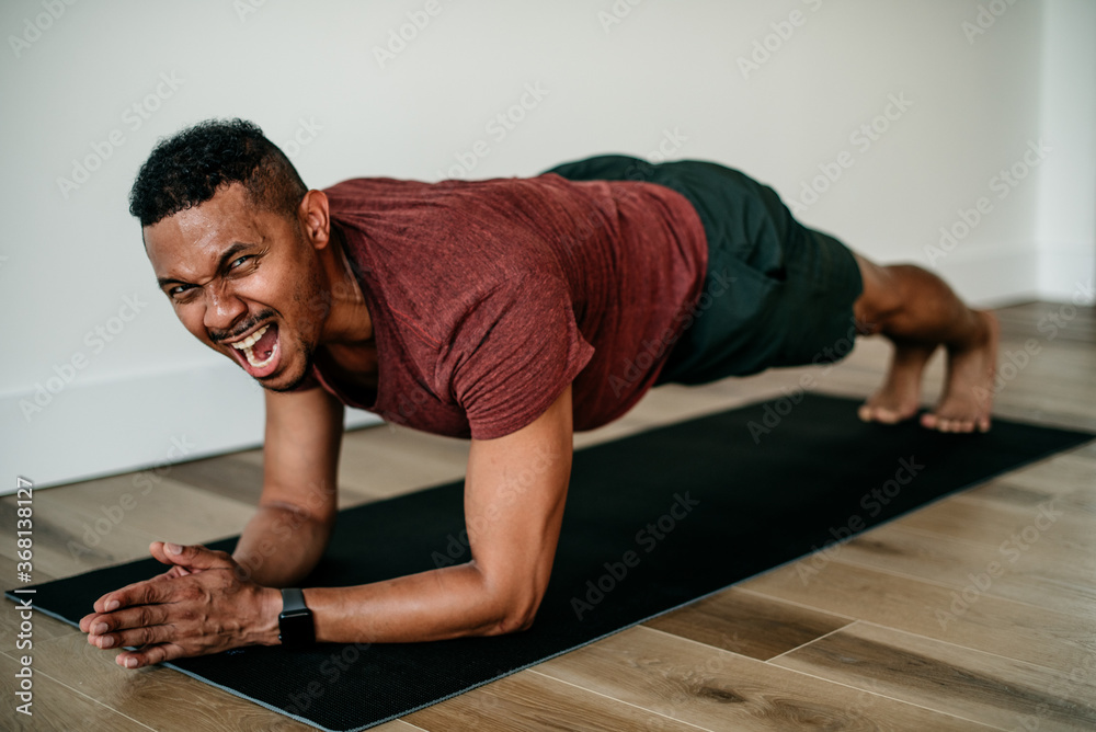Man smiling holding plank yoga pose in a gym Stock Photo Adobe Stock