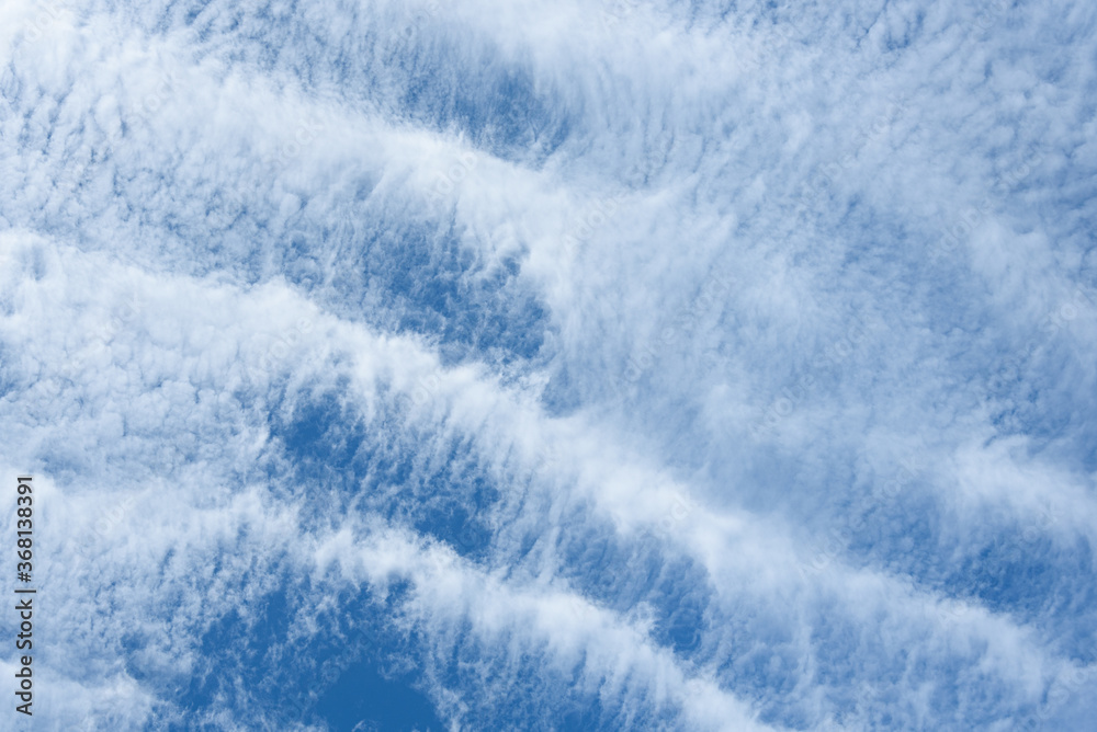 Obraz premium Blue sky and thin striped white cloud layer as a nature background 