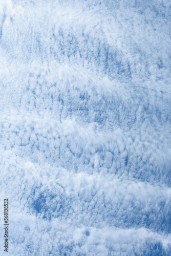 Blue sky and thin striped white cloud layer as a nature background © knelson20