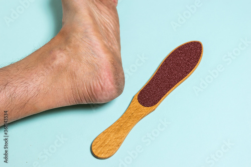 Manual device for removing rough skin and the man's left leg.