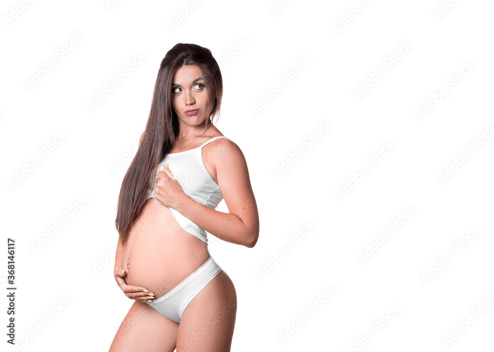 Pregnant woman in white underwear holding her tummy. She looking by side - on copy space. Pregnant woman in white underwear holding her tummy. She looking by side - on copy space.