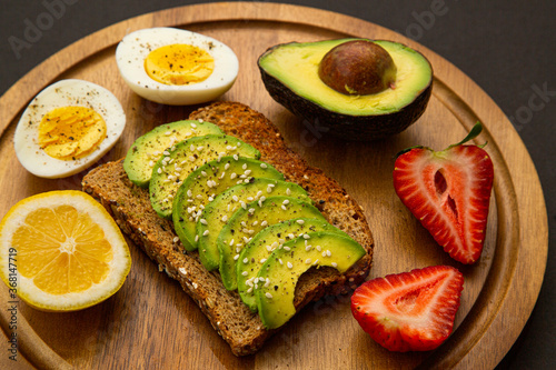 Avocado sandwich on dark rye bread made with fresh sliced avocados and sesame seeds. Yummy and healthy breakfast