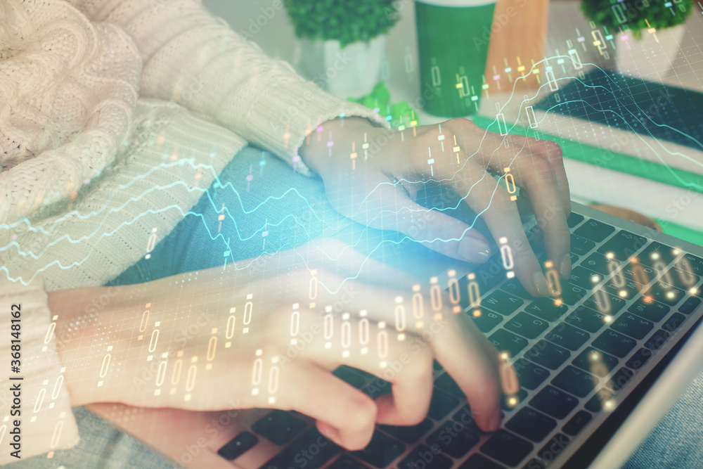 Double exposure of woman hands typing on computer and forex chart hologram drawing. Stock market invest concept.