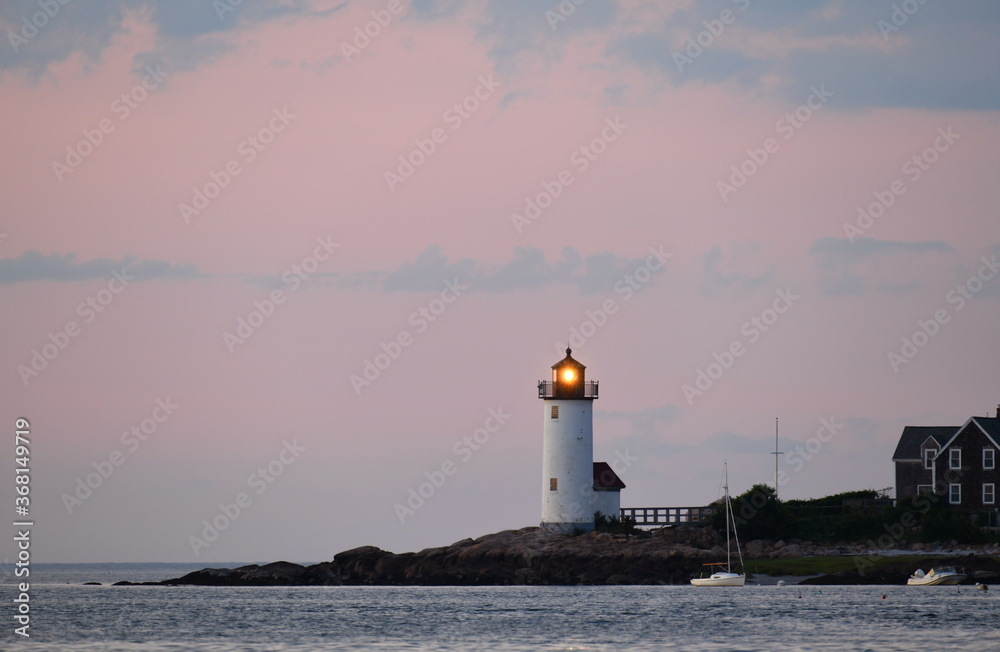 landscape of lighthouse on MA wingaersheek beach seacoast under dusk light