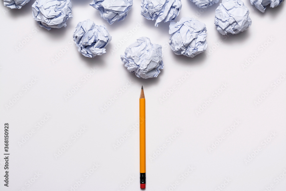 Crumpled paper ball and pencil on the white background
Crumpled paper ball and pencil on the white background