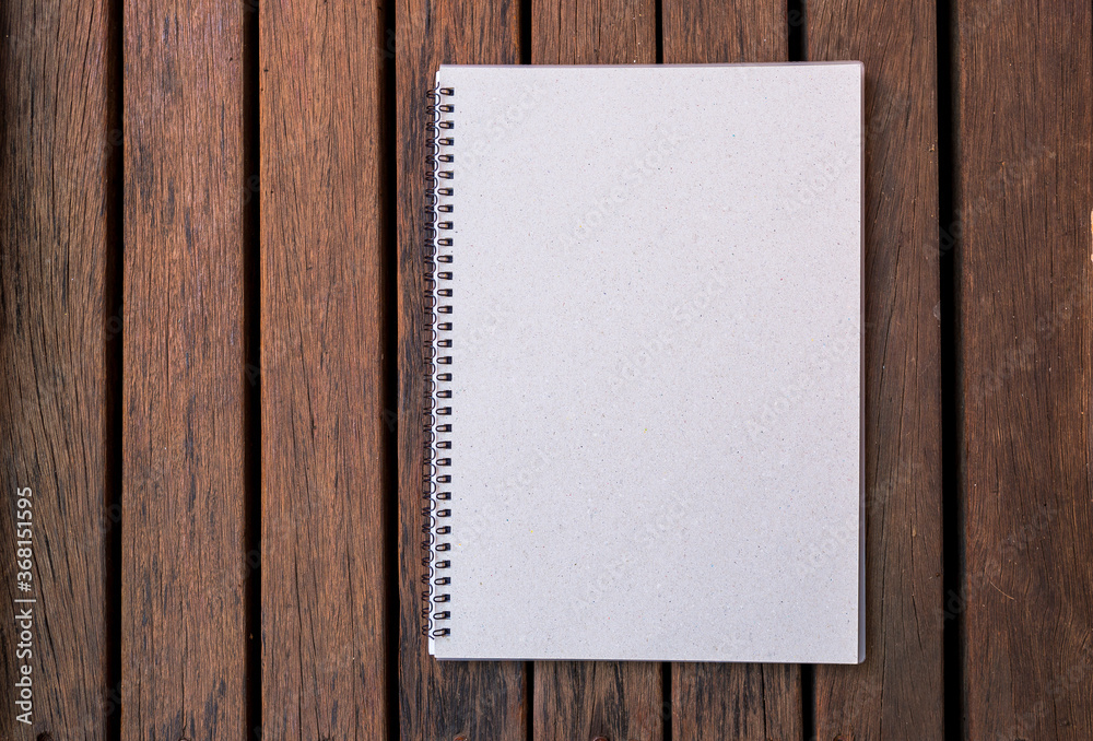 Blank notebook on old wood background, education or object concept vintage style, outdoor day light Blank notebook on old wood background, education or object concept vintage style, outdoor day light