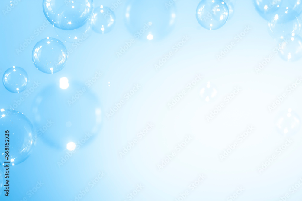 Beautiful blurry clear blue soap bubbles float background with copy space.