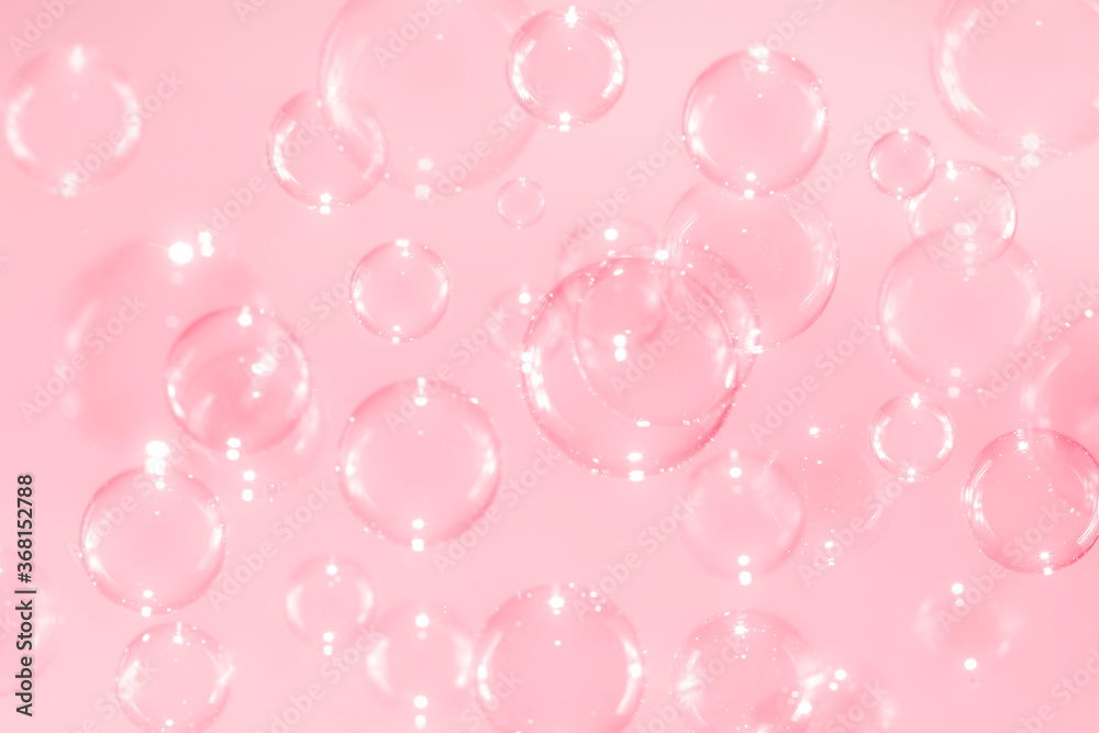 Beautiful blurry clear pink soap bubbles float with reflex background .