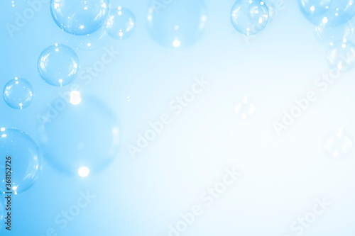 Beautiful blurry clear blue soap bubbles float background with copy space.