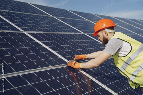 Wallpaper Mural Male worker with solar batteries. Man in a protective helmet. Installing stand-alone solar panel system. Torontodigital.ca