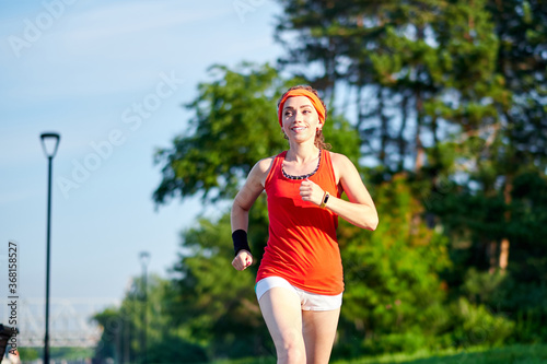 Running woman. Female Runner Jogging during Outdoor Workout in a Park. Beautiful fit Girl. Fitness model outdoors. Weight Loss