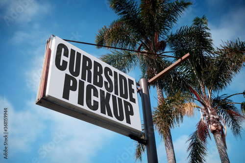 Aged and worn curbside pickup sign with palm trees