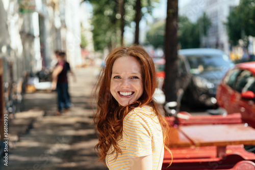 Cute happy young woman turning to grin at camera © contrastwerkstatt